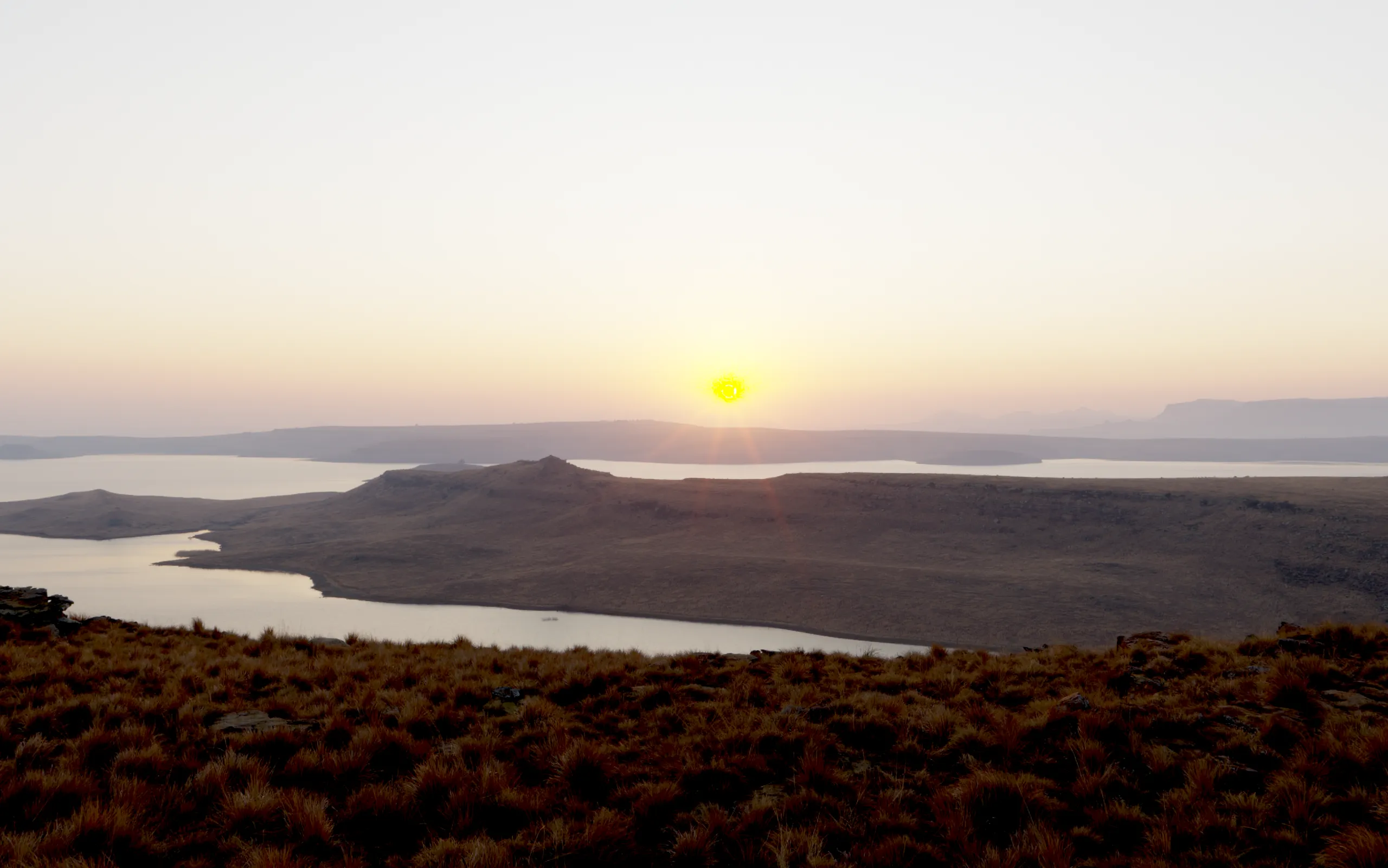 The sun just up over the water, the hills gold at the edges.